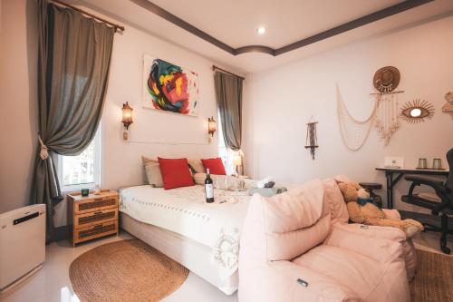 Un dormitorio con una cama blanca y un sofá. en Sunset beach apartment 9 O3 villas, en Ko Pha Ngan