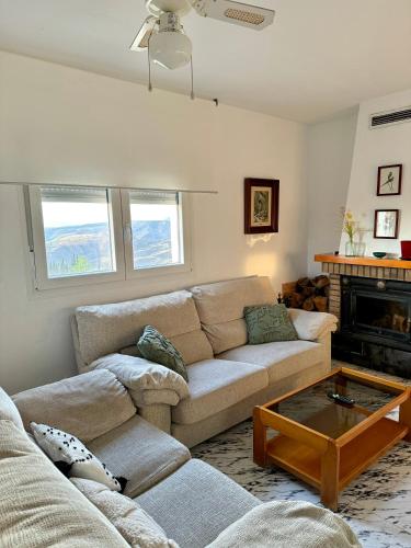 a living room with two couches and a coffee table at Casa rural Balcón de Monachil in Monachil