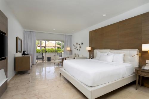a bedroom with a large white bed and a living room at Hyatt Regency Grand Reserve Puerto Rico in Rio Grande