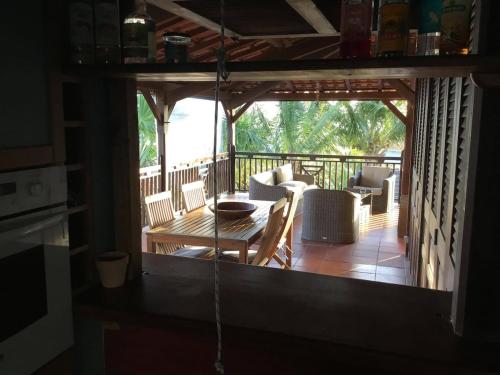 une véranda avec une table et des chaises dans l'établissement Kay Babou, villa avec vue sur les Caraïbes, Case Pilote Martinique, à Case-Pilote
