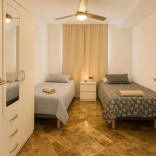 a bedroom with two beds and a ceiling fan at Del Mar Modern Spacious 3-Bedroom Apartment Near the Beach in Puerto de Sagunto