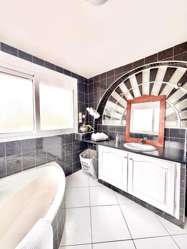 une salle de bain avec une baignoire et un lavabo dans l'établissement Escapade sous la charpente de Vinon sur verdon, à Vinon-sur-Verdon