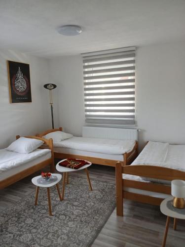 ein Zimmer mit zwei Betten und einem Tisch in der Unterkunft Home in Sarajevo in Doglodi
