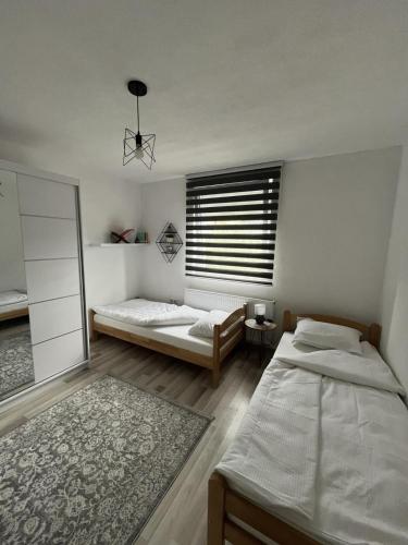 ein Schlafzimmer mit zwei Betten und einem Fenster in der Unterkunft Home in Sarajevo in Doglodi