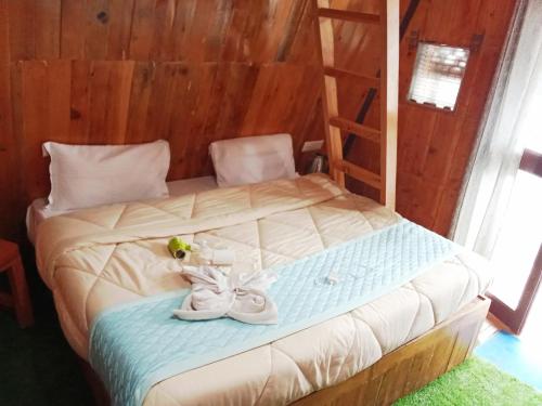ein Bett mit einem Paar Schuhe drauf in der Unterkunft Kaira huts in Manali