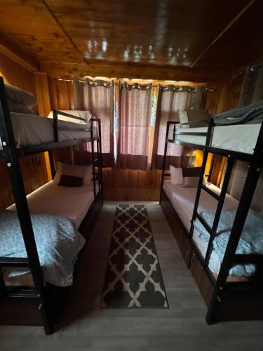 a room with three bunk beds in a cabin at Zoella in Gushaini