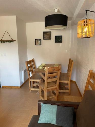 une salle à manger avec une table et des chaises dans l'établissement Front neige 1800, cosy 4-6p, parking couvert, aux Orres