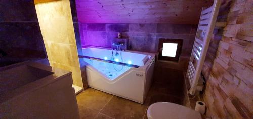 a bathroom with a tub with purple lights in it at Magnifique Chalet avec Balneo in Roubion