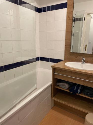 une salle de bain avec une baignoire et un lavabo et une baignoire dans l'établissement Front neige 1800, cosy 4-6p, parking couvert, aux Orres