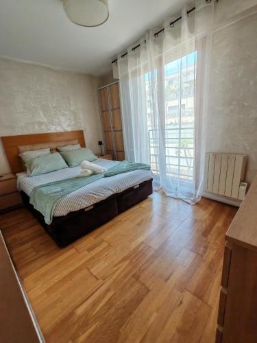 une chambre avec un lit et une grande fenêtre dans l'établissement Bel appartement,à 3 min à pied du Metro, à Clichy