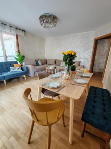 a living room with a table and a couch at Élégance, parking gratuit & à 3 min à pied du Metro in Clichy