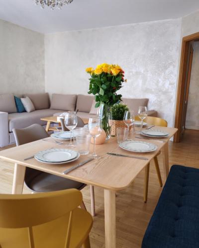 une table de salle à manger avec un vase de fleurs dessus dans l'établissement Bel appartement,à 3 min à pied du Metro, à Clichy