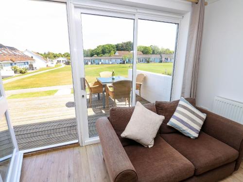 a living room with a couch and a sliding glass door at Cape 12, in Yarmouth