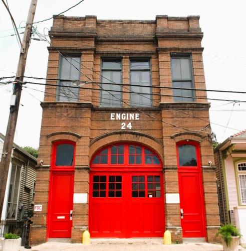 a red brick building with two red doors at Engine 24 Firehouse Bed & Breakfast in New Orleans