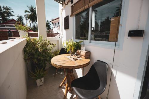 un pequeño balcón con mesa y sillas de madera en Sunset beach apartment 9 O3 villas, en Ko Pha Ngan