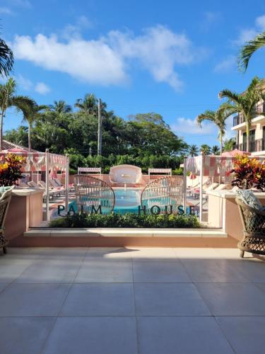 a patio with chairs and a swimming pool at Palm House Hotel Palm Beach in Palm Beach