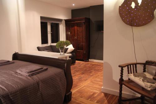 a bedroom with a bed and a couch and a chair at B&B Panorama in Arnhem