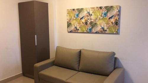 a living room with a couch and a painting on the wall at PARK VEREDAS - Apto 415 - Vista para Piscina in Rio Quente