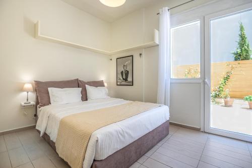 a bedroom with a bed and a large window at White Haven Doukas Residence Platanes Rethymno in Platanes