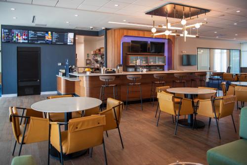 a restaurant with tables and chairs and a bar at Courtyard by Marriott Lake City in Lake City