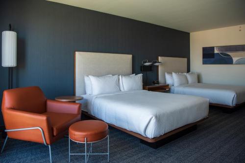 a hotel room with two beds and a chair at Courtyard by Marriott Lake City in Lake City