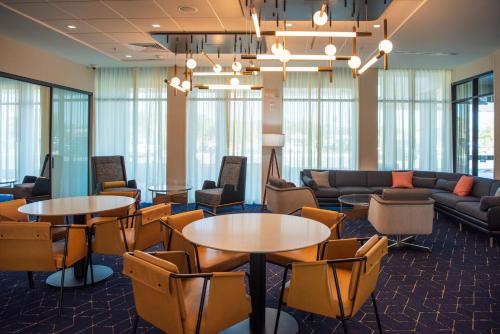 a lobby with tables and chairs and a couch at Courtyard by Marriott Lake City in Lake City