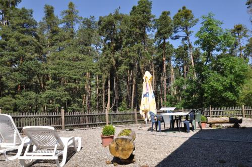 a patio with a table and chairs and an umbrella at Gasthaus Waldheim in Fürstenaubruck