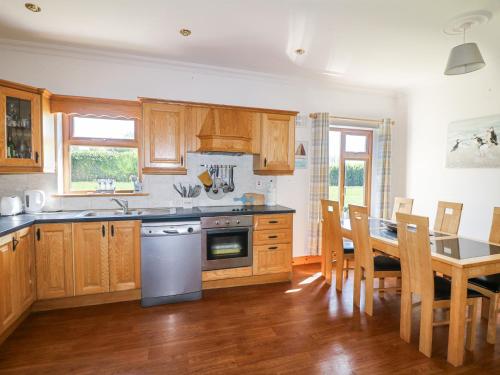 a kitchen with wooden cabinets and a table with chairs at Lacey's Harbour in Duncannon
