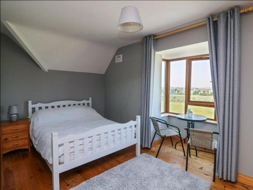 a bedroom with a bed and a table and a window at Lacey's Harbour in Duncannon
