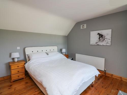 a bedroom with a white bed and a picture on the wall at Lacey's Harbour in Duncannon