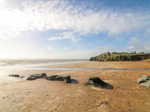 a beach with rocks in the sand and the ocean at Lacey's Harbour in Duncannon