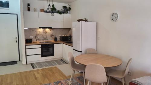 a kitchen with a table and chairs and a refrigerator at BrandNew Apartment in Podgorica