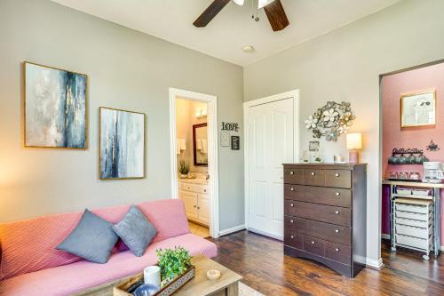 un soggiorno con divano rosa e cassettiera di Explore and Unwind Charming Bedford Apartment a Bedford