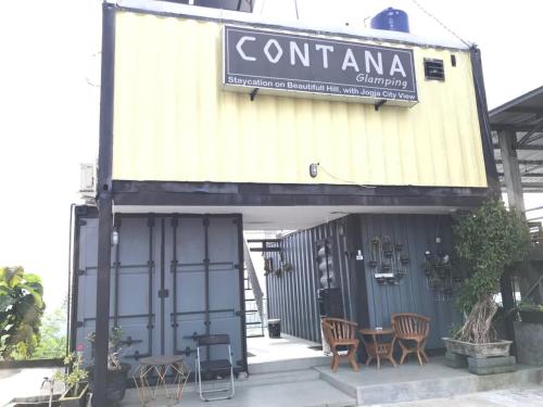 a building with chairs and a table in front of it at Contana By Travelink in Patuk