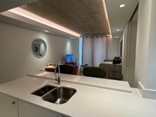 a kitchen with a sink and a living room at High Floor Modern 1BR Stunning Views Balcony AC Free Parking in London