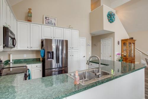 a kitchen with white cabinets and a stainless steel refrigerator at Deck and Views Lake Murray Escape in Chapin! in Chapin