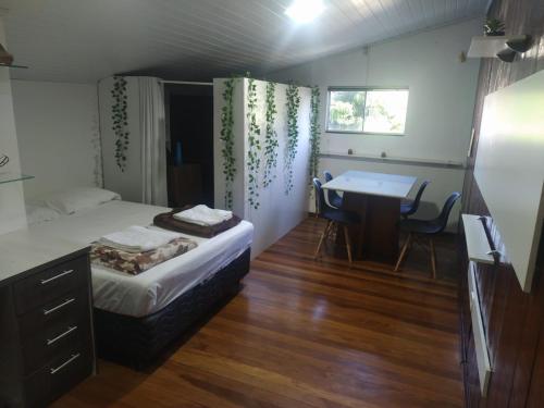 a bedroom with a bed and a desk and a table at Zen Garden Experience - Inn & Bistrô in Foz do Iguaçu