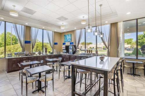 a dining room with tables and chairs and large windows at Best Western Inn & Suites Monroe in Monroe