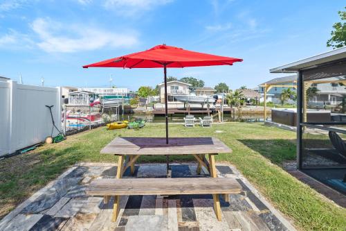 a picnic table with a red umbrella on top at The Hudson Hideout in Hudson