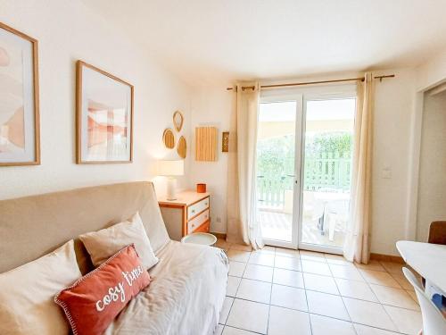 un salon avec un canapé et une fenêtre dans l'établissement Charmant 2 pièce, Terrasse & Climatisation, au Barcarès