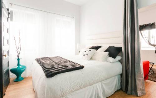 a bedroom with a large white bed with pillows at Lofts du Presbytère in Matane