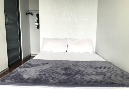a white bed with a black blanket on top of it at Contana By Travelink in Patuk