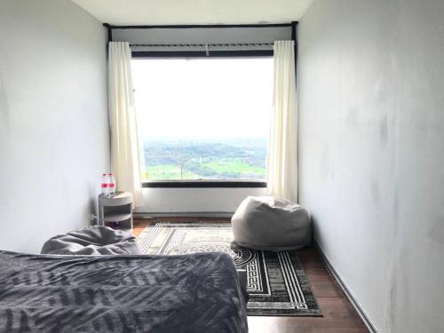 a bedroom with a bed and a large window at Contana By Travelink in Patuk