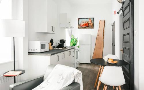 a living room with a table and a kitchen at Lofts du Presbytère in Matane