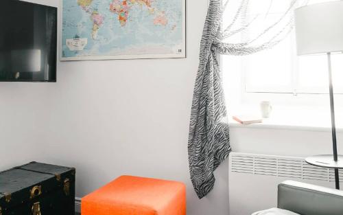 a room with an orange stool and a map on the wall at Lofts du Presbytère in Matane