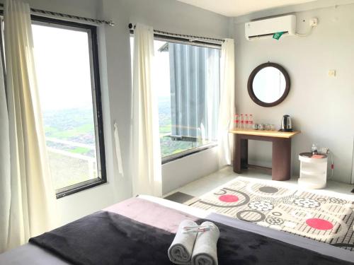 a bedroom with a bed and a large window at Contana By Travelink in Patuk