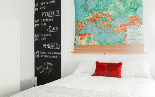 a bedroom with a bed with a map on the wall at Lofts du Presbytère in Matane