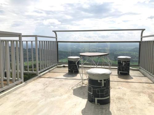 a balcony with a table and two stools on it at Contana By Travelink in Patuk