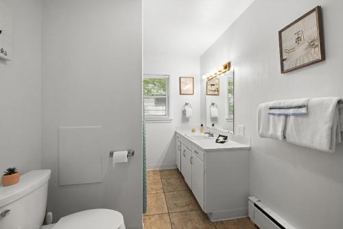 a white bathroom with a toilet and a sink at Bo's Big Green Charming Retreat Hot Tub Games in Billings