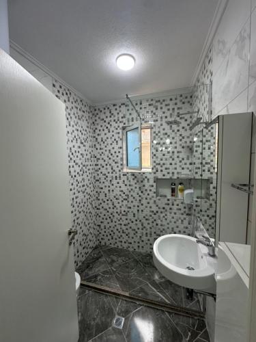 un bagno con lavandino, WC e finestra di Liam'S Apartment a Sarandë